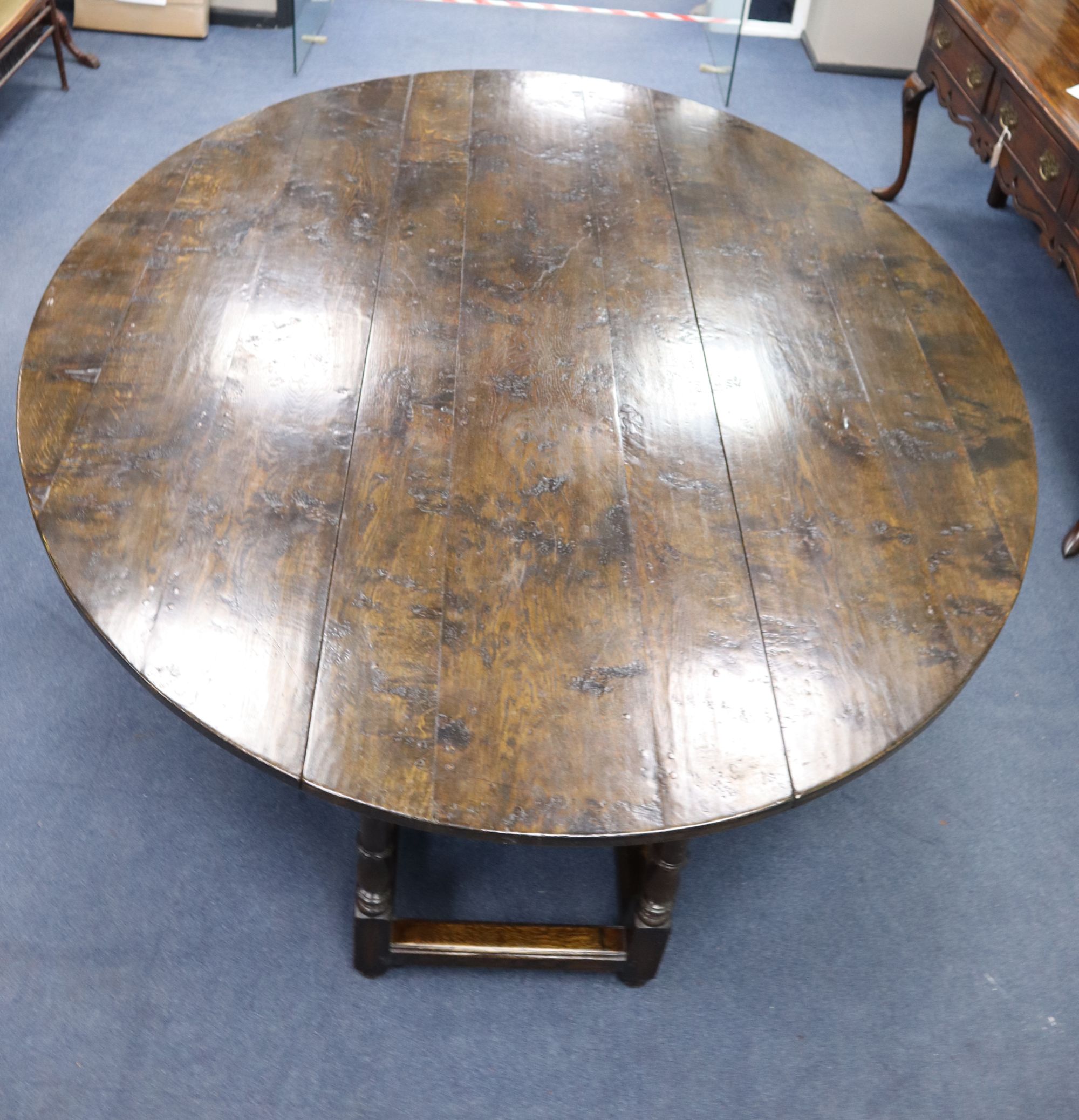 A late 17th century style oak oval topped, double gate leg dining table, width 214cm depth 180cm (extended) height 75cm